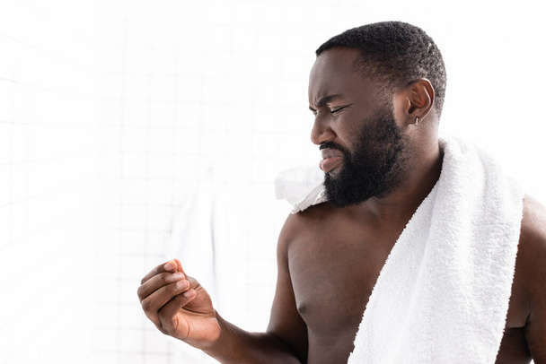 afro-americano uomo guardando orecchio bastone con disgusto - Foto, immagini