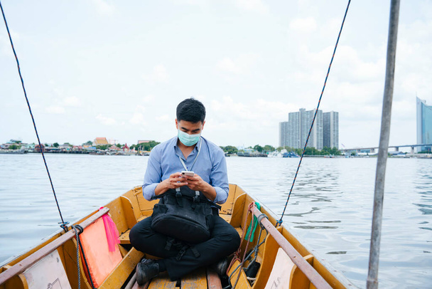 Asian business man wear mask travel by a boat in Bangkok. - Fotoğraf, Görsel