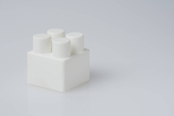 Кубы конструктора, блок на белом фоне. Детские игрушки изолировать вблизи вид сбоку скопировать пространство справа. - Фото, изображение