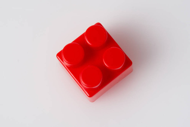Construtor de bloco de cubo vermelho em um fundo branco com espaço de cópia. Conceito de ideia de construção. - Foto, Imagem