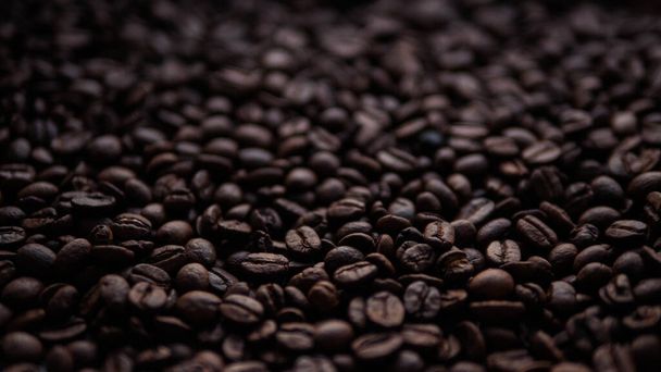 Kávová zrna v tmavé atmosféře, kávová zrna jsou posypaná - Fotografie, Obrázek