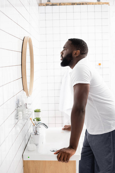 Seitenansicht eines Afroamerikaners, der in den Spiegel schaut - Foto, Bild