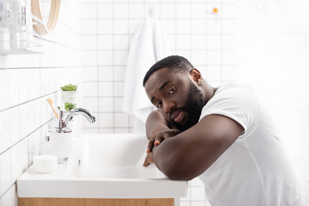 afro-american man leaning on sink and looking at camera - Foto, immagini