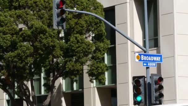 アメリカの柱の上のブロードウェイの通りの名前、同義記号および交通信号。街のダウンタウンの道路の交差点。都市中心部のビジネス地区の交差点。大通りのタイトルを持つネームプレートバナー - 映像、動画