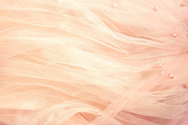 Beautiful nude pink tulle with shiny beads background. Draped background of pink powdery fabric, texture. Copy space - Photo, Image