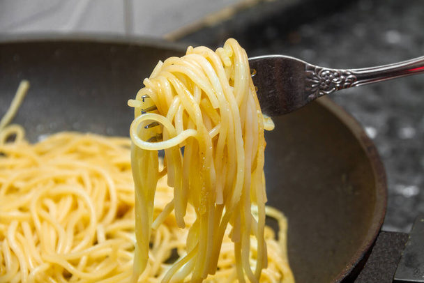 Fried spaghetti rolled on a fork close-up. - 写真・画像