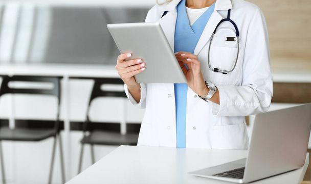 Unbekannte Ärztin bei der Arbeit in Klinik. Ärztin mit Tablet-Computer, Nahaufnahme. Medizinkonzept - Foto, Bild