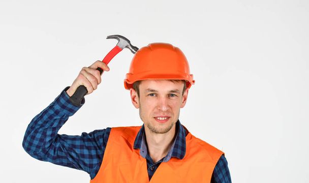 man builder use hammer. professional repairman in helmet. build and construction. skilled architect repair and fix. engineer worker career. tools for repair. young man in hard hat - Фото, изображение