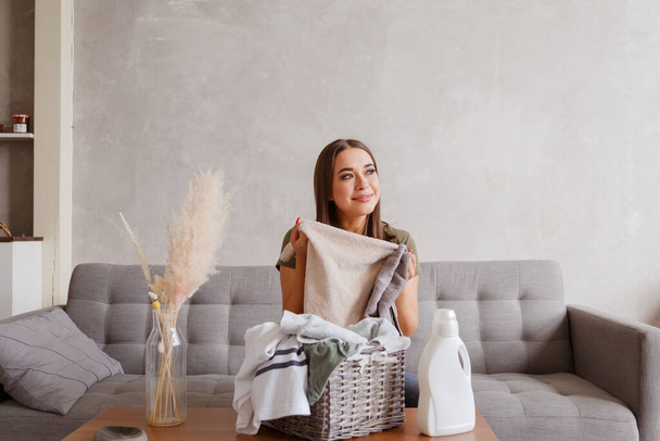 Girl enjoys clean and smelling towels after washing with new detergent gel. - Foto, immagini