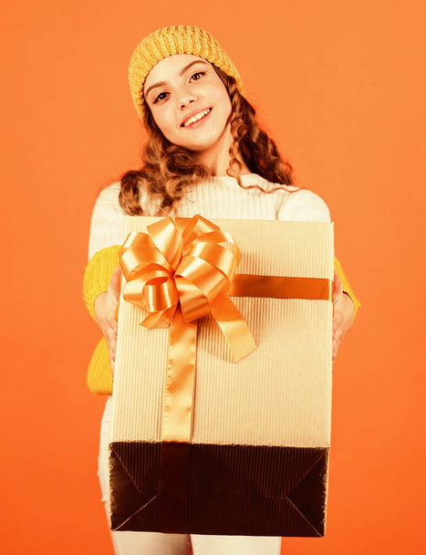 Birthday tradition. Fashionable little girl wear knitted hat and sweater. Birthday surprise. Pretty teen makeup face curly hairstyle. Kid hold present box. Shopping mall. Birthday celebration idea - Fotoğraf, Görsel
