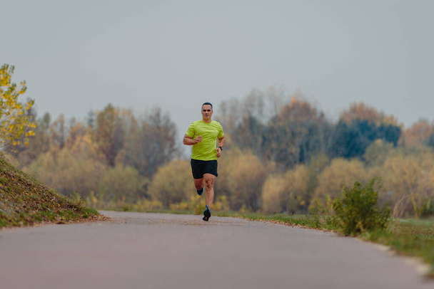 Хорошо сложенный зрелый бегун, одетый в спортивную одежду, отправляется на пробежку - Фото, изображение