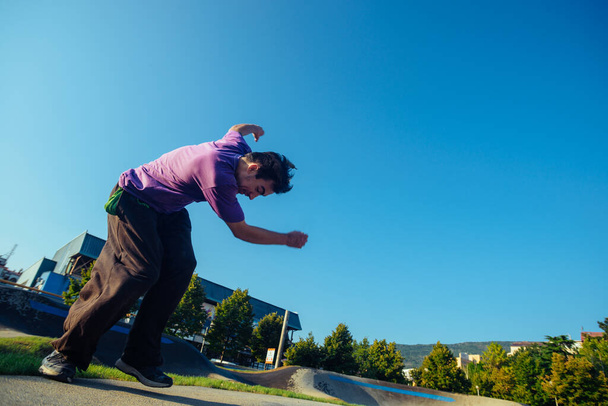 Мужчина, исполняющий акробатику в скейт-парке - Фото, изображение
