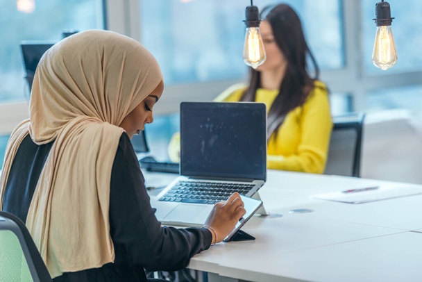 Educação empresarial e conceito de escritório. Empresária afro-americana vestindo um hijab trabalhando, digitando em um pc (computador). Mulher empresária sentada em sua mesa. - Foto, Imagem