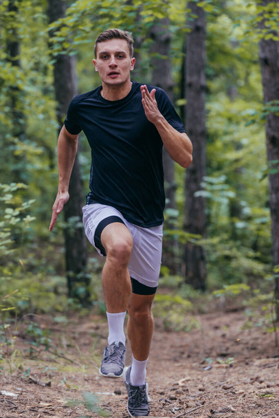 Photo rapprochée d'un jogger jogging dans la forêt - Photo, image