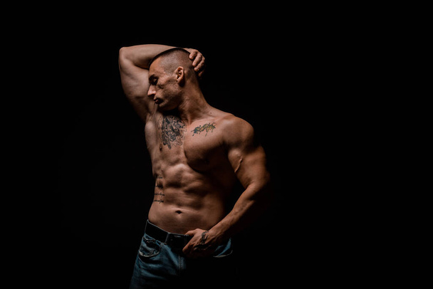 Πορτρέτο ενός γυμνασμένου άνδρα που δείχνει το καλά εκπαιδευμένο σώμα του - Φωτογραφία, εικόνα