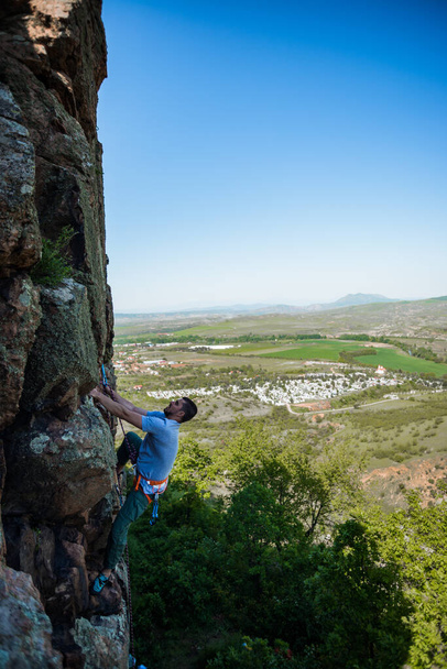 Retrato de fuerte ajuste deportivo macho está escalando la gran roca natural en el tiempo de verano - Foto, imagen
