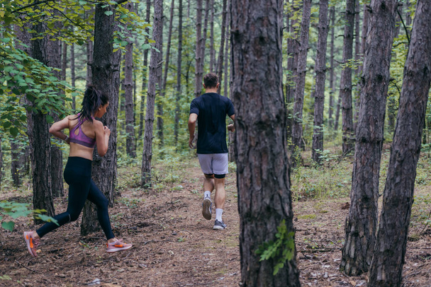 Férfi és női sportolók futnak a természetben. Természet és sport fogalma. - Fotó, kép
