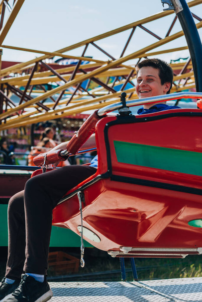 Підліток катається на захоплюючій гойдалці в парку розваг
 - Фото, зображення
