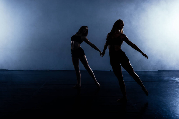 Ballet interpretado por un par de artistas bailarines con canchas negras. - Foto, imagen