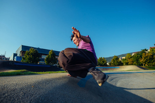Atlétikai férfi parkour akrobatikát végez a skateparkban - Fotó, kép