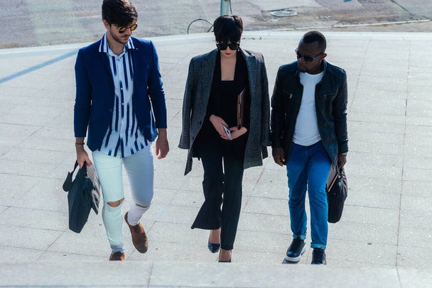 Junge moderne multiethnische Menschen in formaler Kleidung diskutieren vor dem Bürogebäude über Geschäfte - Foto, Bild