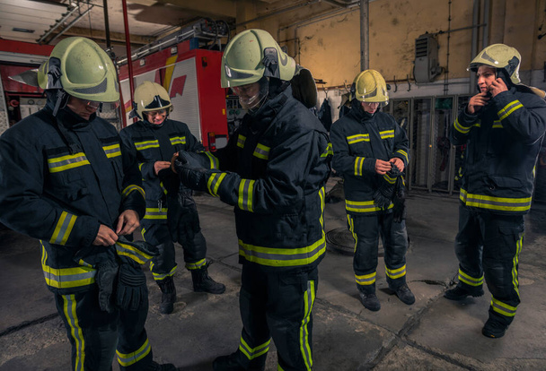 Vigili del fuoco in preparazione al servizio di emergenza. Vigili del fuoco che indossano guanti. - Foto, immagini
