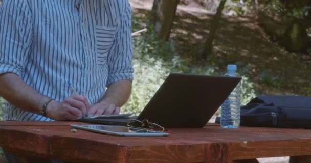 Freelancer working remotely from the forest, medium shot - Footage, Video