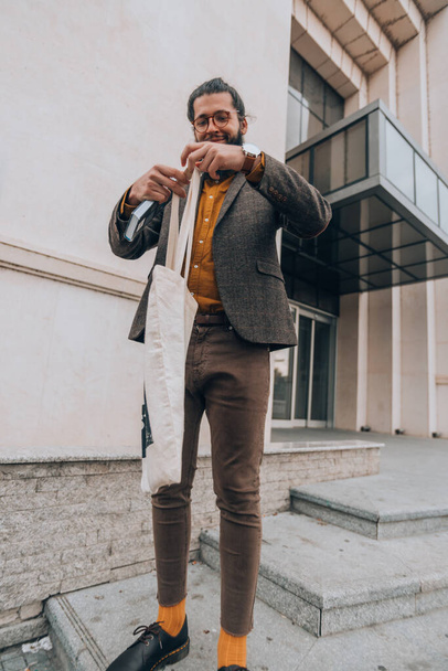 Przystojny, pewny siebie mężczyzna ubrany w nowoczesne ubrania w miejskim otoczeniu - Zdjęcie, obraz