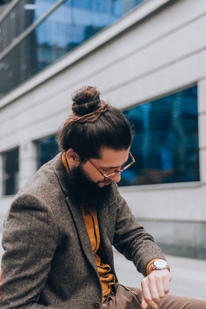 Nowoczesny hipster facet z długimi włosami i brodą w centrum miasta - Zdjęcie, obraz