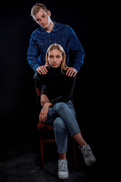 Attractive young man and woman posing against a black background - Valokuva, kuva