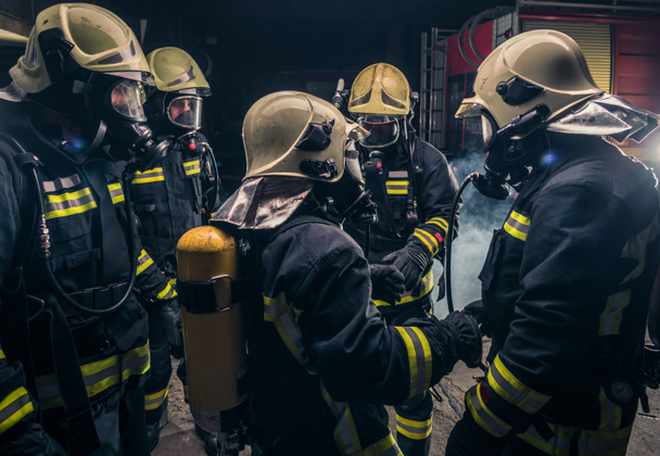 Grupo de bomberos en el departamento de bomberos revisando su equipo de máscara de gas - Foto, imagen