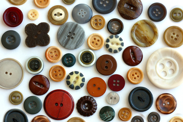 Коллекция старинных кнопок, разбросанных на белом фоне
 - Фото, изображение