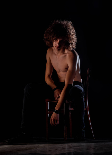 Adolescente sin camisa chico con afro peinado aislado sobre un fondo negro - Foto, Imagen