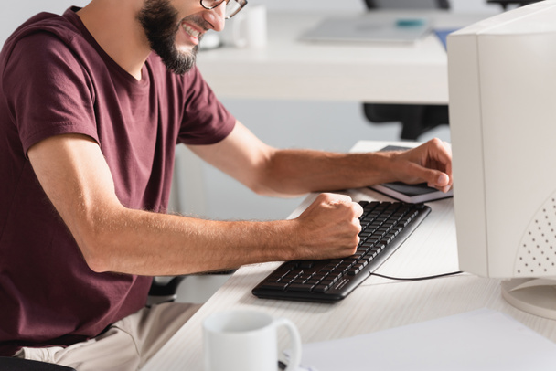 Ausgeschnittene Ansicht gestresster Geschäftsmann schlägt Computertastatur im Büro  - Foto, Bild