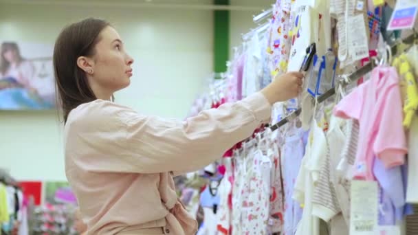 mother in children clothes store - Footage, Video
