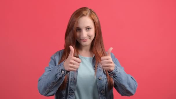 Beautiful woman showing thumbs up, isolated over a red background. - Footage, Video