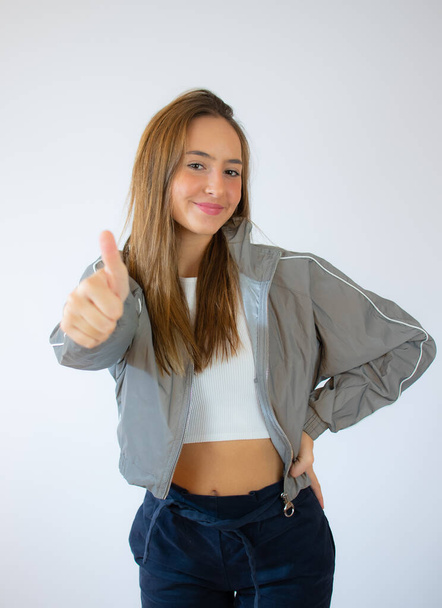 portrét atraktivní úsměv dospívající dívka show palce nahoru gesto, izolované přes bílé pozadí - Fotografie, Obrázek