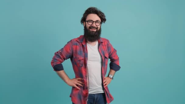 Portrait of smiling bearded man pointing at you over turquoise background. - Footage, Video