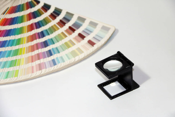 Lupa cuadrada negra y catálogo de paletas de colores de muestra de arco iris, libro de muestras de color aislado en fondo blanco.  - Foto, Imagen