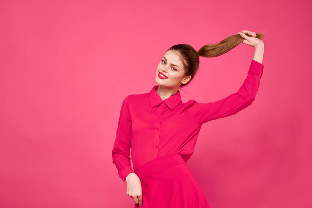 ピンクの背景に明るい服を着た赤い髪の女性の肖像画は、彼女の手でジェスチャーのビューをトリミング - 写真・画像