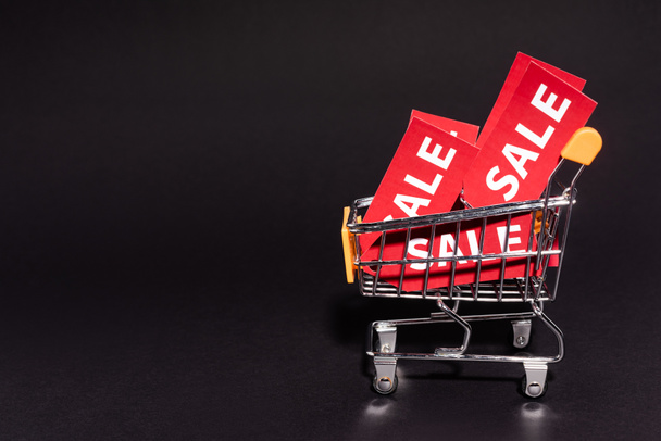 toy cart with sale tags on dark background, black friday concept  - Φωτογραφία, εικόνα