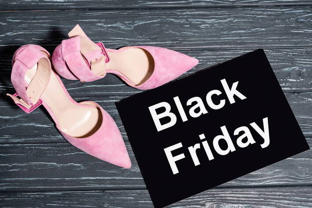 top view of pink shoes near placard with black friday lettering on wooden surface - Φωτογραφία, εικόνα