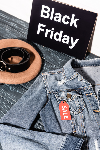 giacca di denim blu vicino al cartello con scritta nera venerdì, berretto e cintura  - Foto, immagini