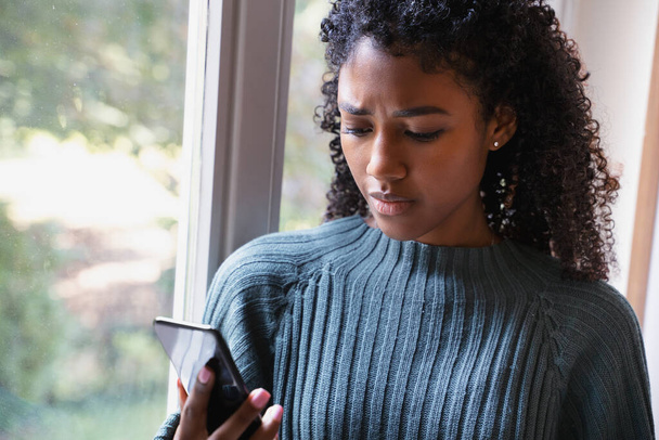 Сумна чорна жінка чекає повідомлення на мобільному телефоні
 - Фото, зображення