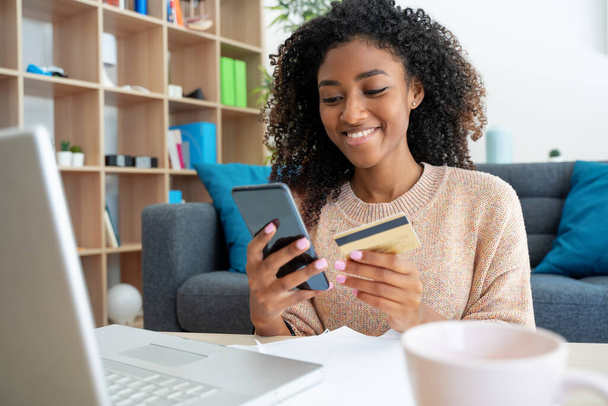 Чернокожая женщина использует кредитную карту для онлайн-покупок - Фото, изображение
