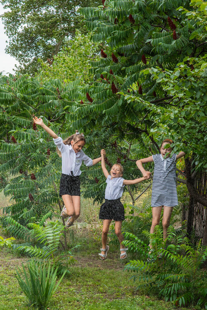 Yağmurda üç kız öğrenci. Öğrenci kızlar sıcak havada yağmurda koşarlar. Üç kız arkadaş. - Fotoğraf, Görsel