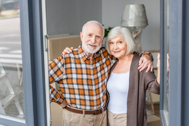 Fröhliches Seniorenpaar umarmt sich in neuem Haus - Foto, Bild