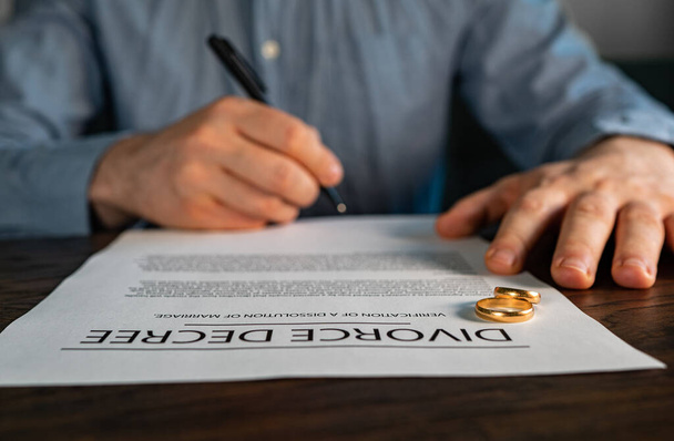 Σύζυγος υπογραφή της συμφωνίας διαζυγίου που εκπονήθηκε από δικηγόρο. - Φωτογραφία, εικόνα