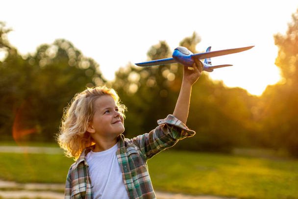 Little boy playing with toy plane in park - Zdjęcie, obraz