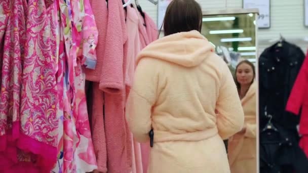 donna sta cercando accappatoio nella zona di trading del supermercato - Filmati, video